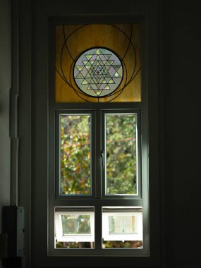 Kilisedeki beyaz pencereler boyalı camlarla süslenmiş..