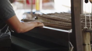 Kadın eli dokuma ipliği, ipek iplik ve örgü örmek için mekanik ahşap makine kullanılarak örülmüş. Dokuma ve geleneksel el sanatları.