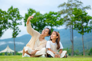 Mutlu anne ve kız baharda bir parkta birlikte vakit geçiriyorlar..
