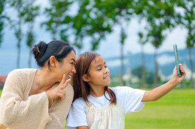 Mutlu anne ve kız baharda bir parkta birlikte vakit geçiriyorlar..
