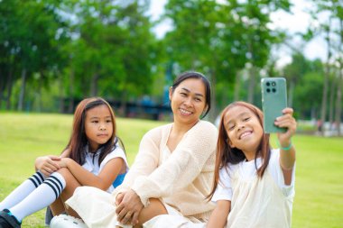 Mutlu anne ve kız baharda bir parkta birlikte vakit geçiriyorlar..