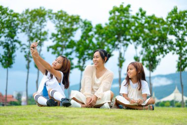 Mutlu anne ve kız baharda bir parkta birlikte vakit geçiriyorlar..