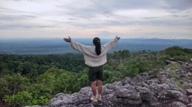 Mutlu genç bayan turist bahar tatili boyunca dağ ormanlarının güzel doğasıyla dışarıda eğleniyor..