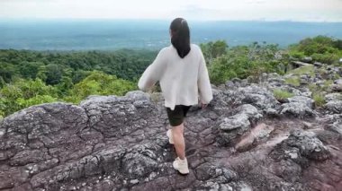 Mutlu genç bayan turist bahar tatili boyunca dağ ormanlarının güzel doğasıyla dışarıda eğleniyor..