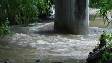 Yağmur mevsiminde güçlü bir şekilde akan ormandaki şelalenin doğası. Nehirdeki güçlü akıntı, sonbaharda sağanak yağışlardan sonra sular çamurlu oldu..