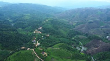 Yağmurlu mevsim manzarası sabah bir dağ köyü ve arka planda dağlar.