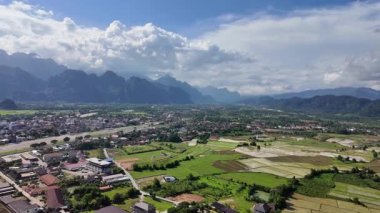 Dağlarla çevrili ovaların ve Laos köylerinin kuş bakışı manzarası.