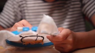 Bir kızın elinin yakın plan bir çerçeve ile bir nakış çemberi işlemesi. El yapımı bir kız tuvale dikiş deseni.