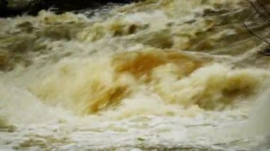 Yağmur mevsiminde güçlü bir şekilde akan ormandaki şelalenin doğası. Nehirdeki güçlü akıntı, sağanak yağmurdan sonra sular çamurlu oldu..