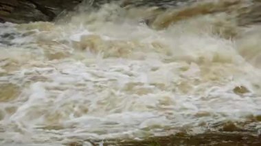 Yağmur mevsiminde güçlü bir şekilde akan ormandaki şelalenin doğası. Nehirdeki güçlü akıntı, sağanak yağmurdan sonra sular çamurlu oldu..