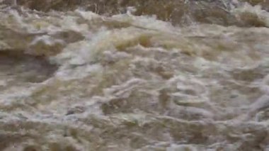 Yağmur mevsiminde yemyeşil bir ormanda çağlayan güçlü bir şelale. Nehir akıntısı güçlüdür ve şiddetli yağıştan sonra su çamurlu hale gelir. Bu da doğanın ham enerjisini gösterir.