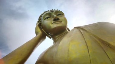 Altın uzanan Buda heykeli, dramatik gökyüzü ile alçak bir açıdan çekilmiş, ruhani ve kültürel kavramlar için mükemmel..