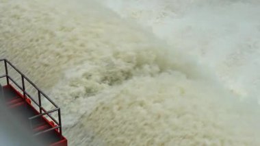 Nehrin aşağısındaki barajın güçlü akım ve kahverengi çamur akıntısıyla sel sularını serbest bırakması.