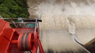 Nehrin aşağısındaki barajın güçlü akım ve kahverengi çamur akıntısıyla sel sularını serbest bırakması.
