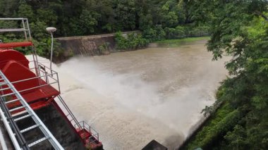 Nehrin aşağısındaki barajın güçlü akım ve kahverengi çamur akıntısıyla sel sularını serbest bırakması.