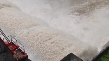 Nehrin aşağısındaki barajın güçlü akım ve kahverengi çamur akıntısıyla sel sularını serbest bırakması.