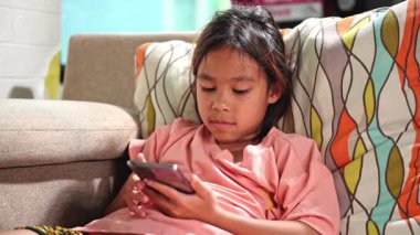 Bir elinde akıllı bir telefon tutan genç bir kız, düşünceli ya da düşünceli bir ifade sergiliyor. Teknoloji, yaşam tarzı ve çocuk duyguları konuları için harika..