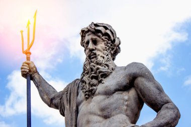 Mavi bir arka planda, güneş ışığındaki Neptün heykeli. Yunan mitolojisi
