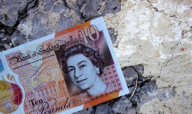 Geçmişe yakın planda on İngiliz poundu. Büyük Britanya 'nın ulusal para birimi