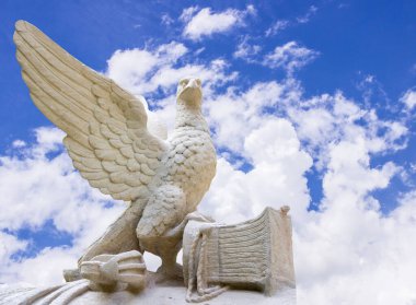 Statue of an eagle with large wings close-up on a sky background. Symbol of freedom and liberty