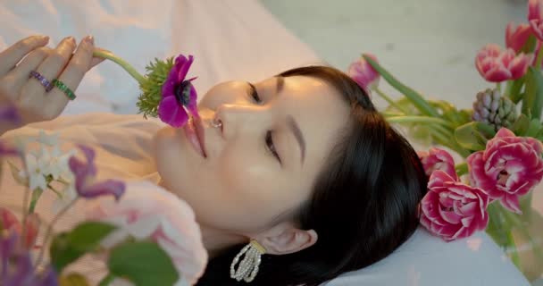 若いかわいいアジアの女性がアパートで花束を持っています — ストック動画