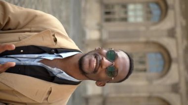 Koyu tenli yakışıklı adam kasabada yavaş bir yürüyüş yapıyor, sohbetin tadını çıkarıyor. Akıllı telefonuna ve fotoğraf makinesine mesajlar yazıyormuş. Şık kıyafetler giyiyorlar. Paris.