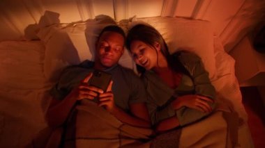 Asian woman and black man are trying to fall asleep in a noisy apartment snoring. High quality 4k footage