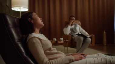 Asian girl with a psychologist, talking mental problems, during psychotherapy.