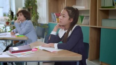 Elementary school class, children communicate with the teacher, answering various questions.