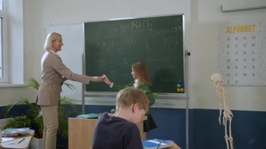 Elementary school class, children communicate with the teacher, answering various questions.