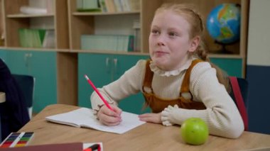 Elementary school class, children communicate with the teacher, answering various questions.