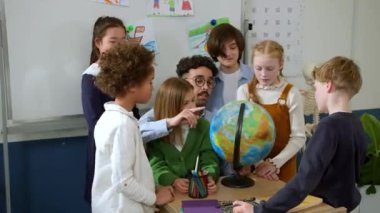 Elementary school class, children communicate with the teacher, answering various questions.