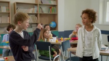 Elementary school class, children communicate with the teacher, answering various questions.