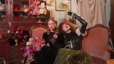 A cute young girl a vintage stylish dress near vintage furniture in a interior.