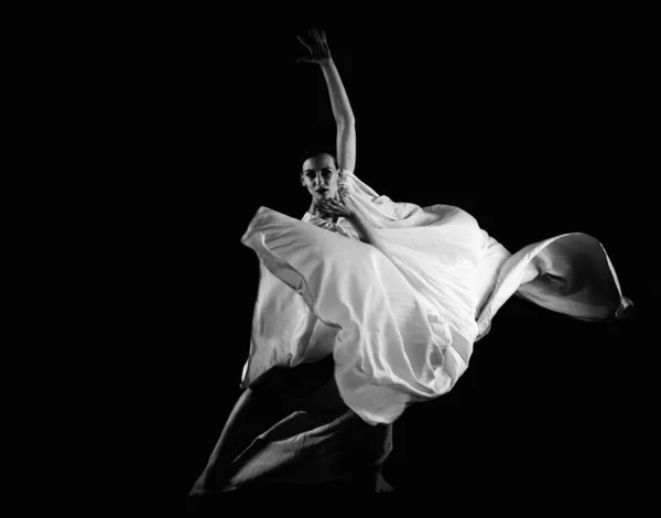 Dancer in a white robe.Beautiful lyrical dancer on a black background.