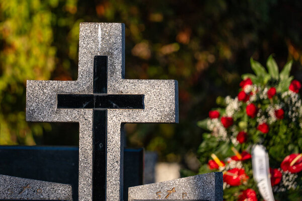 Close up of a stone cross on a grave in a cemetery.Poland