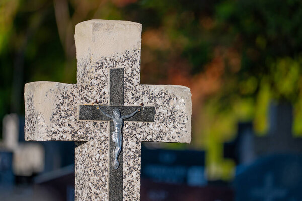 Close up of a stone cross on a grave in a cemetery.Poland
