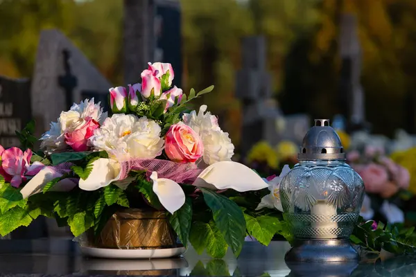 万圣日期间 墓碑上的花朵和蜡烛 墓地死者坟墓上的五彩缤纷的花朵 免版税图库图片