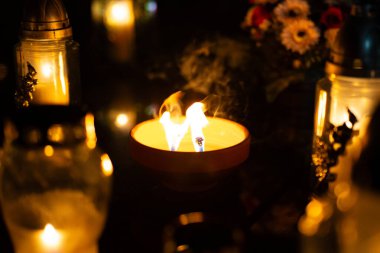 Geceleri mezarlıkta mumlar yanıyor. Seçici odaklanma. Geceleri mezarlıkta mumlar. Derin tarlalar. Geceleri mezarlıkta fenerler. Azizler Günü.