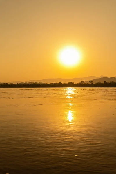 stock image View of the morning Mekong River surrounded by mountains and yellow sunbeams in the sunset background at Chiang Khong, Chiang Rai, northern Thailand.