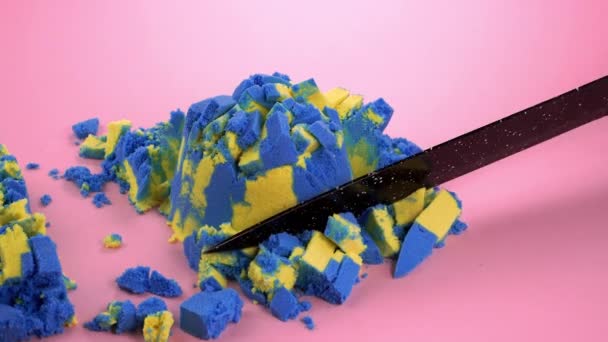 Резание Кинетического Песка Ножом Многоцветном Фоне — стоковое видео