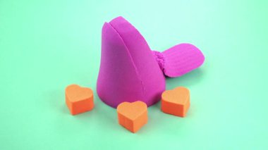 Çok renkli bir arka planda, kinetik kumu bıçakla kesmek.