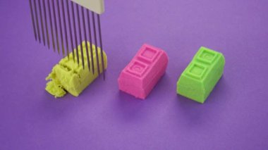 Renkli bir arka planda bıçakla Kinetik kum kesimi. ASMR sesleri. Çok tatmin edici ve rahatlatıcı Kinetik Kum ASMR videosu. Stres önleyici makroyu keserek renkli Kinetik Kumu bıçakla kapatıyoruz..