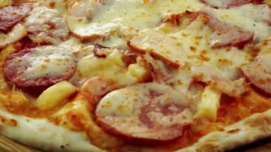 Siyah arka planda peynirli ve sosisli lezzetli pizza..