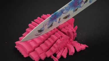 Çok tatmin edici ve rahatlatıcı Kinetik Kum ASMR. Stres önleyici makroyu renkli Kinetik Kumu bıçakla kapatmak. Kinetik kum kesimi, siyah arka planda bir bıçakla. ASMR .