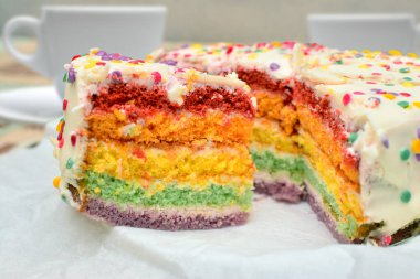 Beyaz kremalı ve şekerli renkli gökkuşağı pastası.