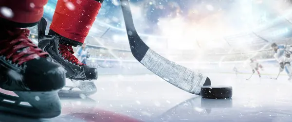 Hokey diski ve yakın çekim. Buz arenasında hokey oyuncusu. Diske odaklan. Hokey konsepti. Buz. Hokey stadyumu. Spor.