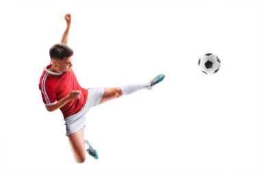 Futbol hareketi. Genç profesyonel futbolcu hareketli, topa güçlü bir tekme atıyor. Tekmeye odaklan. İzole edilmiş. Spor.