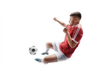 Futbol vuruşu. Başla. Genç profesyonel futbolcu hareketli, topa güçlü bir tekme atıyor. Tekmeye odaklan. İzole edilmiş. Spor.