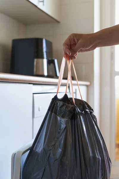 stock image Hand removing black rubbish bag with debris from kitchen waste bin